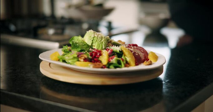 Hands, person and plate with salad in kitchen for presentation, lunch served and dining aesthetic. Chef, spin board and cooking food, vegetable decoration and meal preparation for catering service