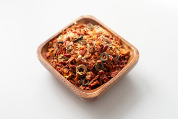 Mix of dried vegetables from tomatoes, onions and olives in a wooden bowl. Natural organic food seasoning. Vegetable soup mix. Spices top view