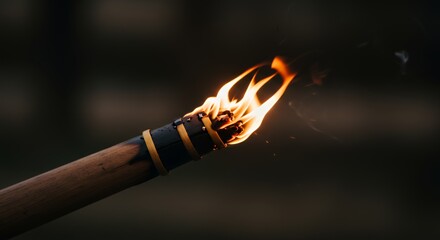 Lit tiki torch with bright flames illuminating the dark surroundings outdoors