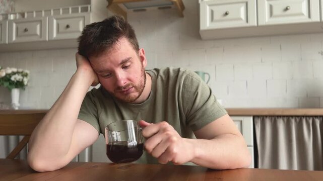 man suffering from lack of sleep and depression in the kitchen in the morning