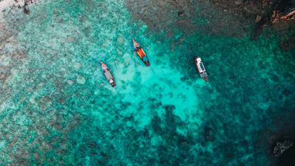 Fototapeta premium Long Tail Boats on Crystal Clear Waters at a Hidden Beach in Koh Phi Phi, Thailand