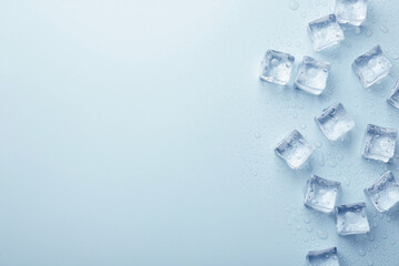 Crystal clear ice cubes on light blue background, flat lay. Space for text