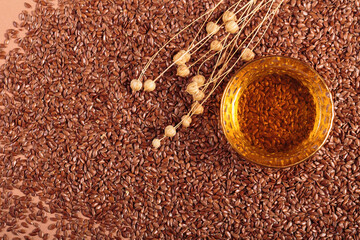Brown linen seeds, flaxseed vegetable oil on beige background. Flaxseed background. Healthy super food top view, flat lay with copy space