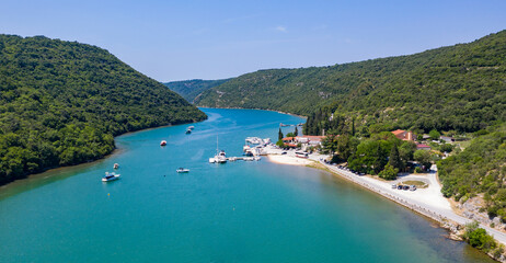 Fototapeta premium Aerial drone view of the sea and islands. High-resolution top-down drone shot of sea, sky, islands and clear sky. Soft lighting ideal for travel, landscape or nature themes.