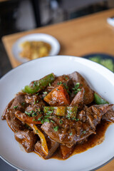 A plate of meat with Potato and herbs