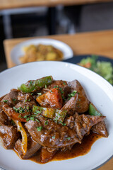 A plate of meat with Potato and herbs