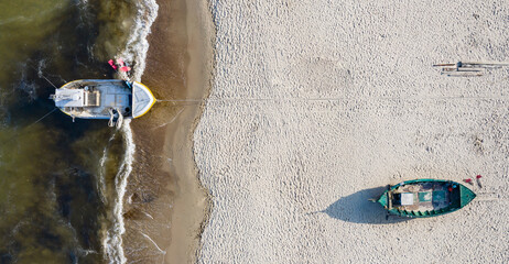 Boats on the seashore seen from above. Aerial view of sandy beach.