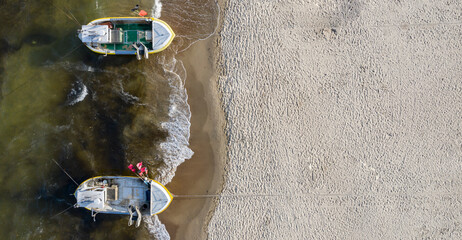 Boats on the seashore seen from above. Aerial view of sandy beach.