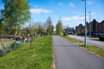 Cycling route along backyards at old train route L  85 in Kluisbergen, East Flemish Region, Belgium