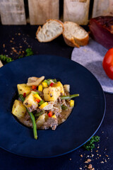 Bauern Fleischsalat in schwarzem Teller
