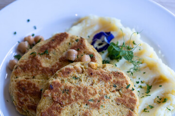 A plate of food with two pieces chickpeas patty