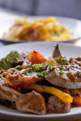 A plate of meat with Potato and herbs