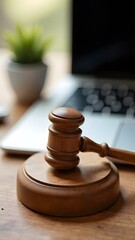 Wooden gavel and modern laptop on desk, legal tech concept
