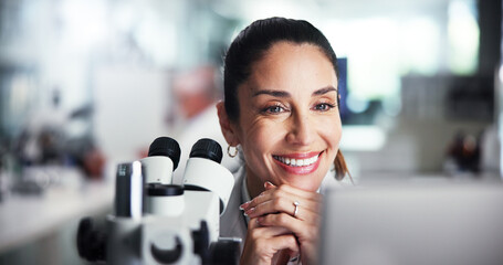 Computer, scientist and smile with woman with microscope for healthcare, medical research or test...