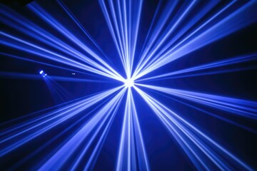 Obraz premium Converging blue light beams create a radiant, starburst effect in a dark space.