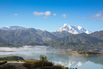 Beautiful landscape of lake and reflection of blue sky, clouds and mountains on surface of lake, Panoramic view of lake and snow-covered mountain and Forest trees calm in Jijel Algeria North African.