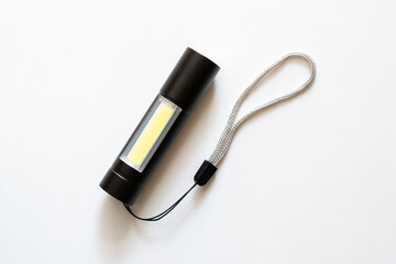 Small pocket portable black flashlight with led bulbs on white