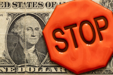One dollar bill and a reflexive sign with the text stop , stop