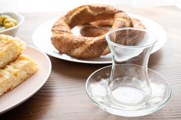 Local Turkish breakfast table Turkish tea, su boregi, green olives and simit bagel