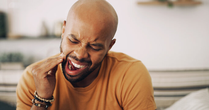 Toothache, sensitive and man in home with dental problem for cavity, gum disease or gingivitis. Pain, dentistry and male person with impacted wisdom teeth for tension, pressure or plaque in house.