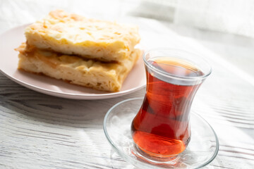 Local Turkish breakfast table Turkish tea, su boregi, green olives and simit bagel	