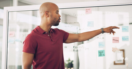 Planning, glass wall and man with sticky note, office and ideas for agenda, brainstorming and...