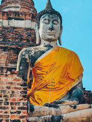 Close-up view of large Buddha statue draped in yellow robes in Ayutthaya, Thailand. 