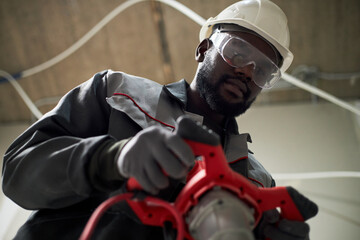 Low angle shot of African American man wearing uniform and protective transparent glasses while...