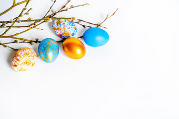 beautiful painted Easter chicken eggs with willow branches on a white background and space for text, for the bright holiday of Holy Easter