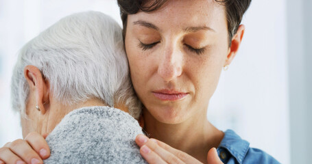 Sad, empathy and woman hugging senior mother in retirement home for grief, support or loss. Crying,...