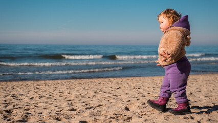 Walking Along the Sandy Beach a Child Enjoys the Serene Atmosphere and Ocean Waves on a Sunny Day