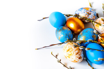 beautiful painted Easter chicken eggs with willow branches on a white background and space for text, for the bright holiday of Holy Easter