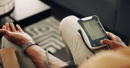 Home, blood pressure and hands of man with machine for test, hypertension and check pulse on sofa. Healthcare, above and person with medical equipment for exam, monitor and measure heart rate