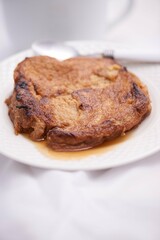 Toronjas - sweet wine-soaked bread with raisins, a traditional Easter Week dish from El Salvador on white tableware.