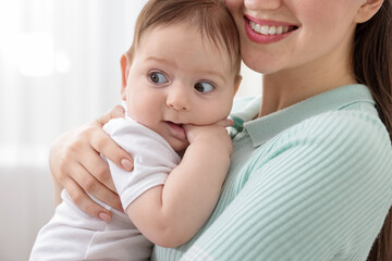 Mother with her cute little baby at home, closeup