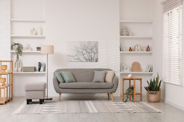 Stylish furniture, houseplants and different decor in light living room. Interior design