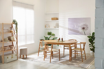 Stylish room with wooden table, chairs and houseplants. Interior design