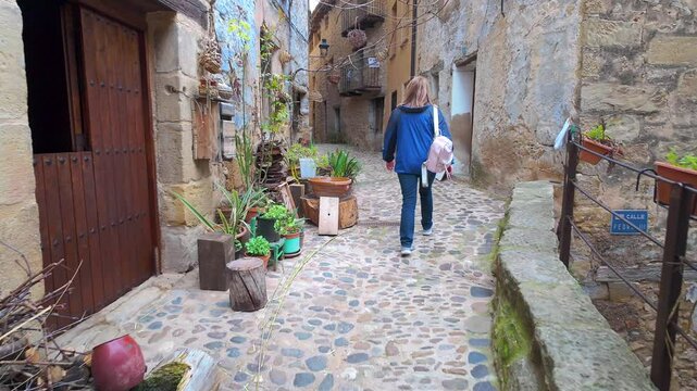 Tourist woman walking through the picturesque alleys of the medieval village of Valderrobres, Teruel.
