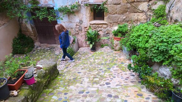 Tourist woman walking through the picturesque alleys of the medieval village of Valderrobres, Teruel.