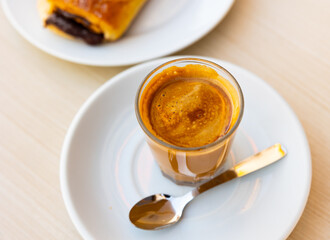 Cup of fresh cortado, Spanish beverage made of espresso with dessert