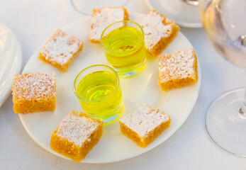 Square slices of traditional Spanish almond cake Tarta de Santiago on white plate