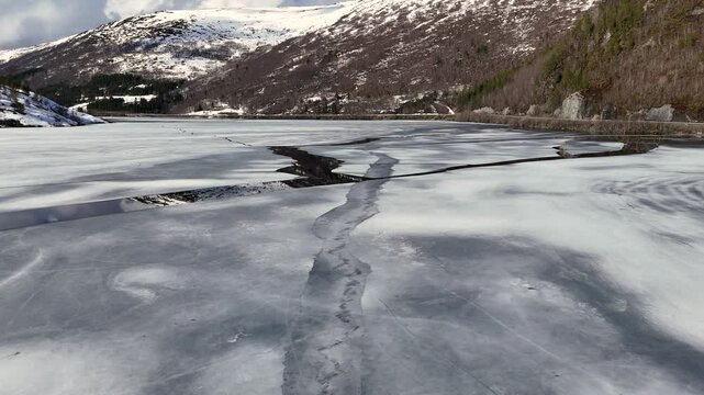 Aerial view of snow-covered Lake Vasslivatnet nestled in the mountains blanketed in winter white