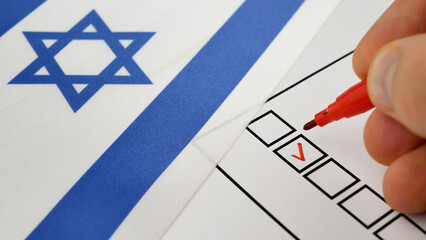 Person uses red marker to select candidate on ballot. Democratic elections in Israel. Flag with Star of David in background. Voting process reflects civic responsibility in shaping leadership 