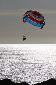 Parasailing or parascending recreational water sport with boat on Tenerife, Costa de Adeje, adventure for tourists
