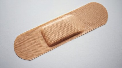 A sterile, hypoallergenic bandage with cotton backing and acrylic adhesive on a white surface.