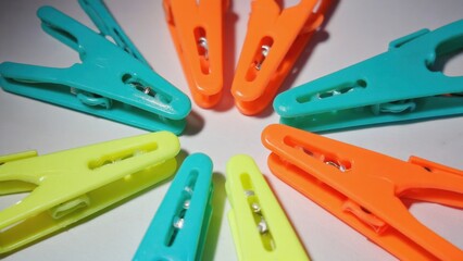 Assortment of colorful plastic clothespins for sewing, garment hanging and storage organization. Easy to use spring clip pegs.