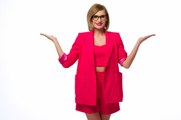 confident woman wearing pink suit poses with arms raised, presenting concept. modern fashion,...