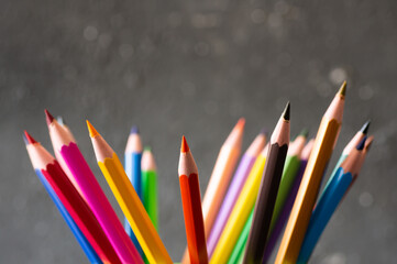 Crayons, colorful dry painting pencils on dark rustic background, back to school art design