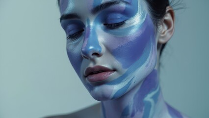 A woman with a painted face is shown, highlighting her neck and shoulders. Blue and purple patterns cover their skin, creating an artistic, textured effect against a solid light background.
