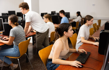 Portrait of interested teen girl during lesson in computer room of school computer class